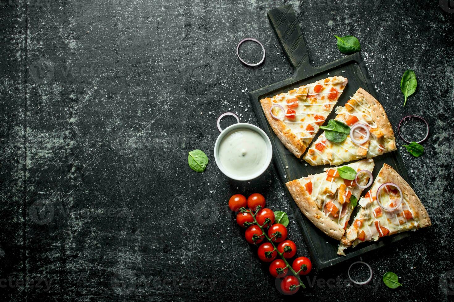 Slices of pizza with tomatoes and cheese sauce in bowl. photo