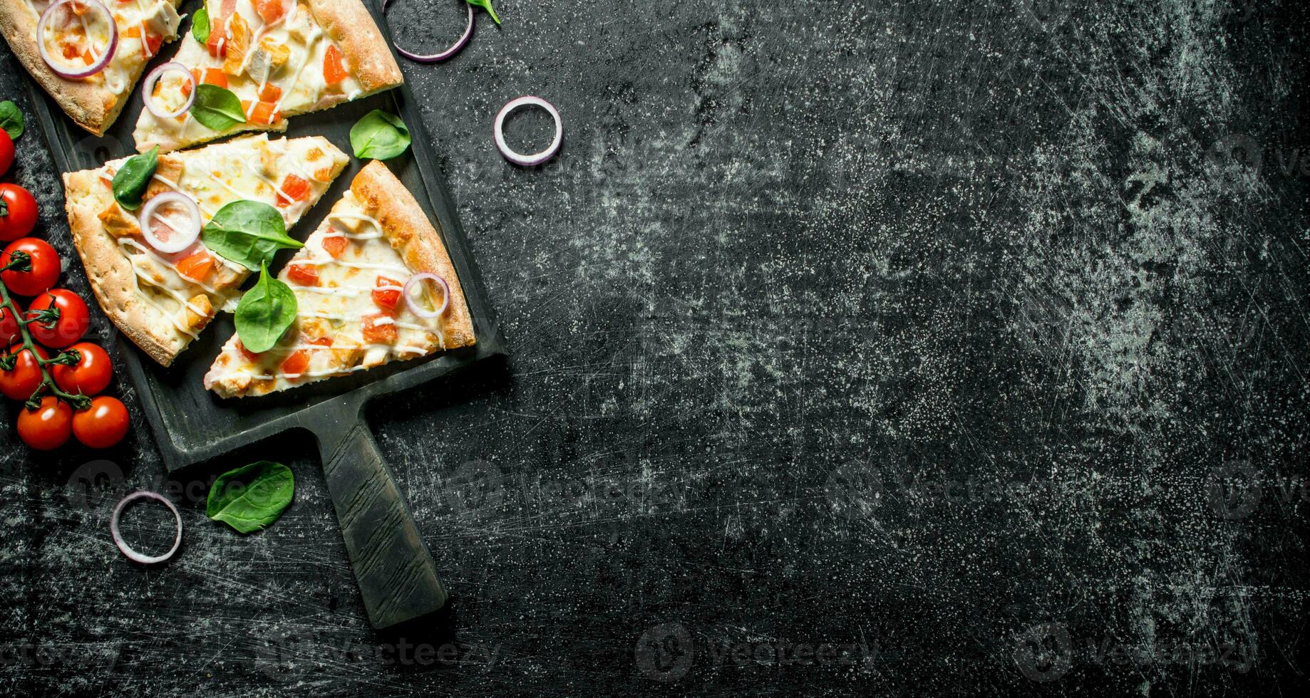 Slices of pizza with tomatoes on a branch and spinach. photo