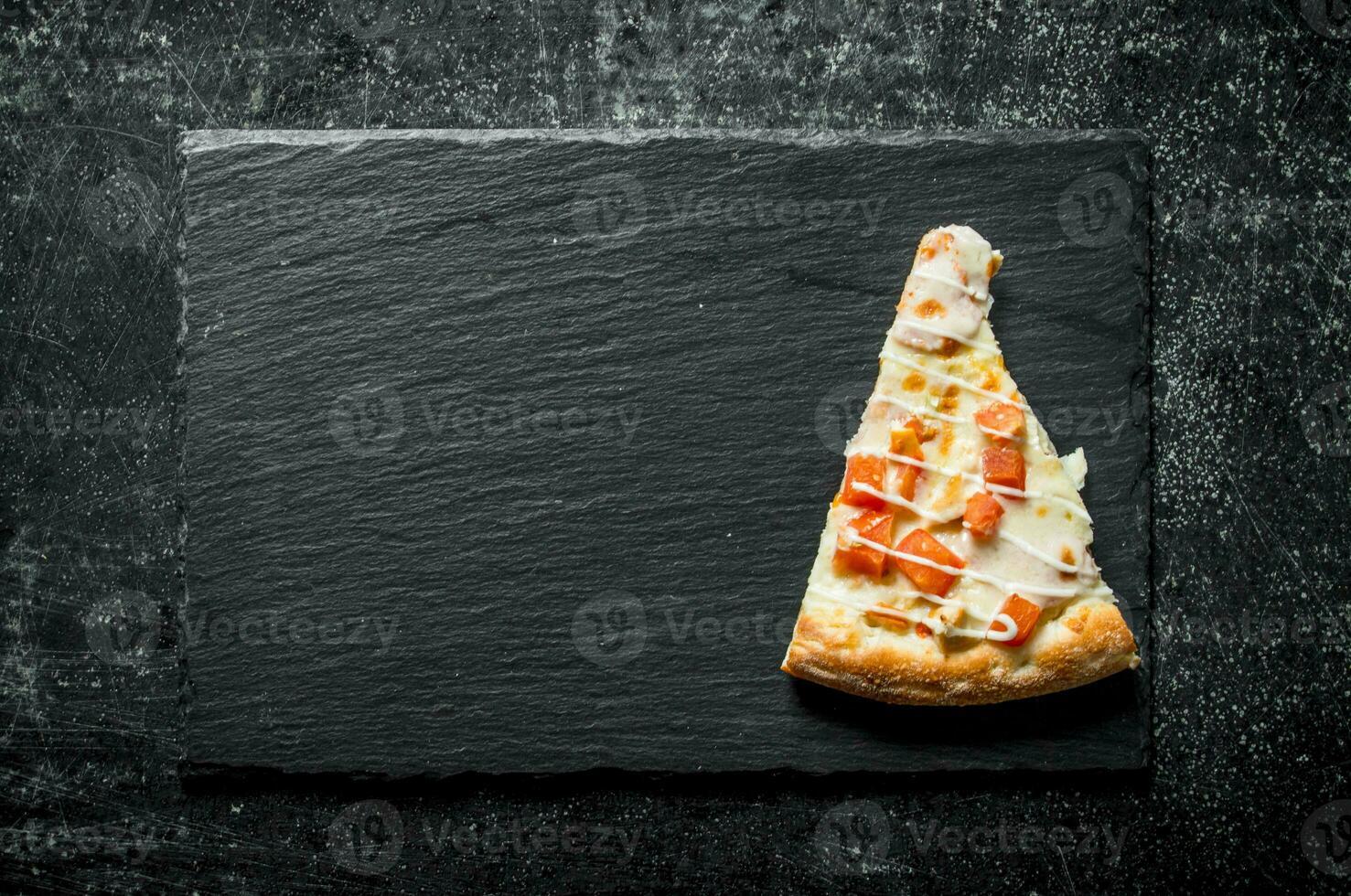 Slice of pizza with chicken, tomatoes and cheese sauce. photo