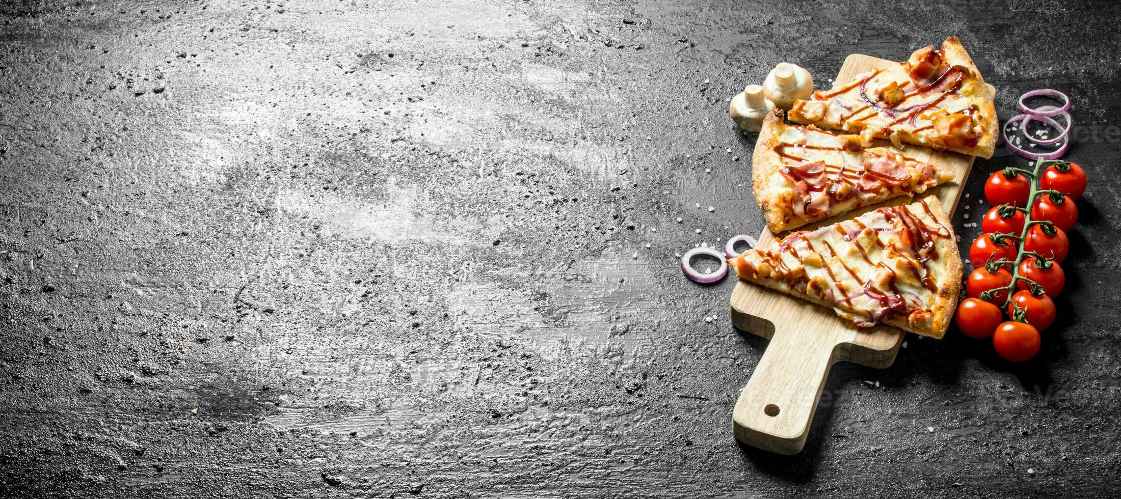 Sliced barbecue pizza with tomatoes on a branch. photo