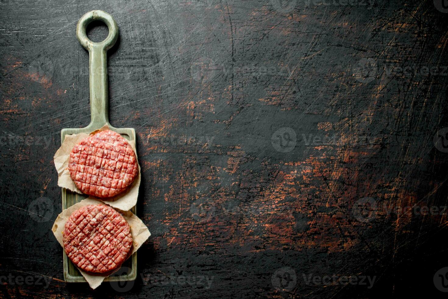 Raw burgers on a cutting Board with paper. photo