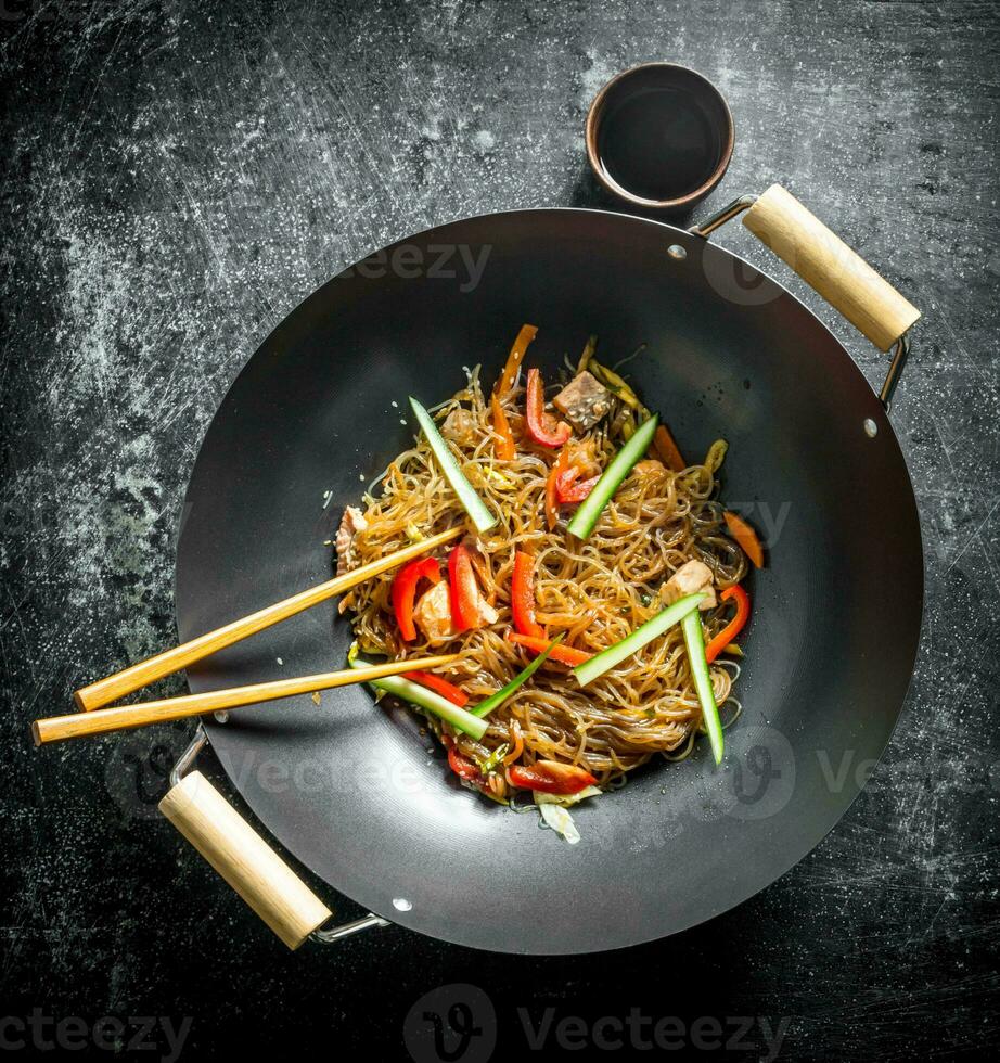 Chinese wok. Asian cellophane noodles with vegetables and chicken in a frying pan wok. photo
