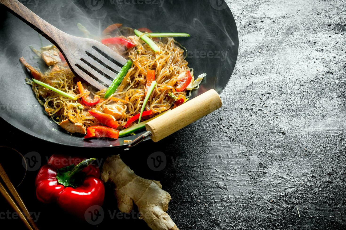 Hot wok Chinese cellophane noodles in a pan with a spatula. photo