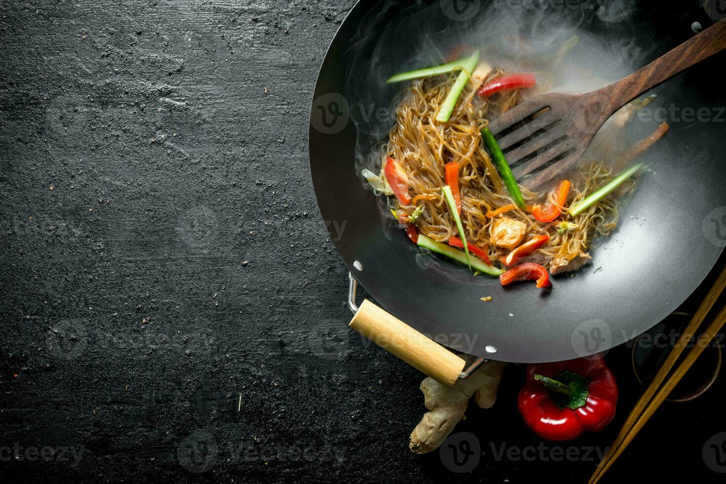 Hot wok Chinese cellophane noodles in a pan with a spatula. photo