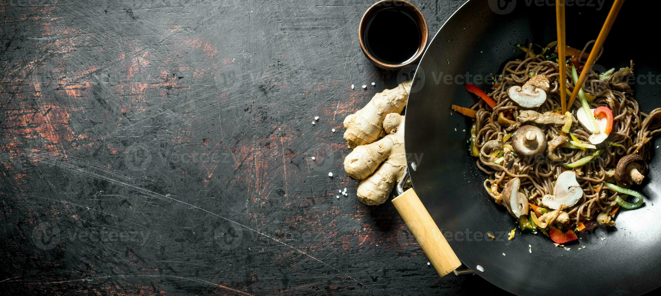 Fragrant soba noodles in a wok pan with mushrooms and fresh vegetables. photo