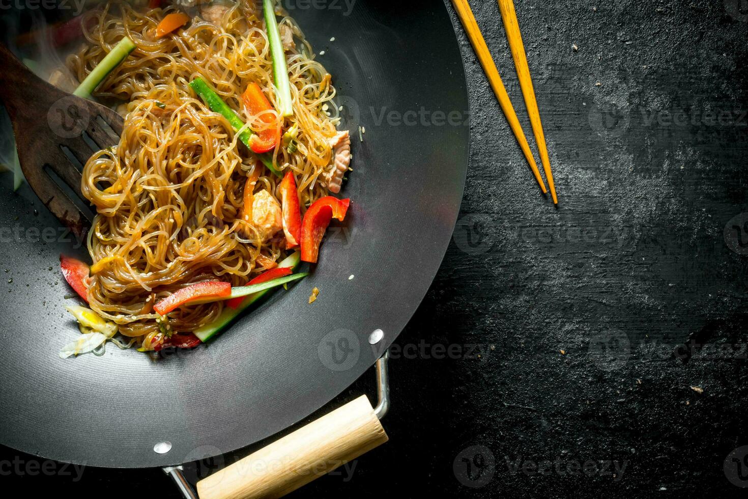 Fragrant Chinese cellophane noodles in a frying pan wok with salmon and vegetables. photo