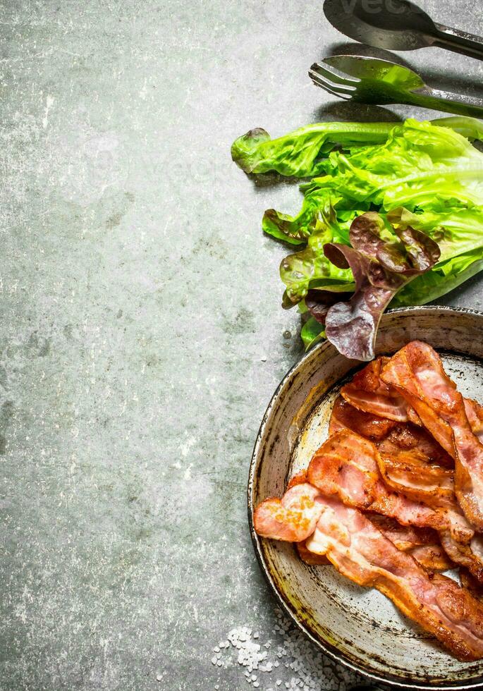 Bacon in a frying pan with salt and herbs. photo