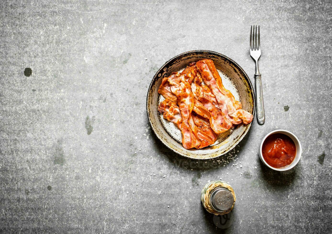 Fried bacon with tomato sauce and salt. photo