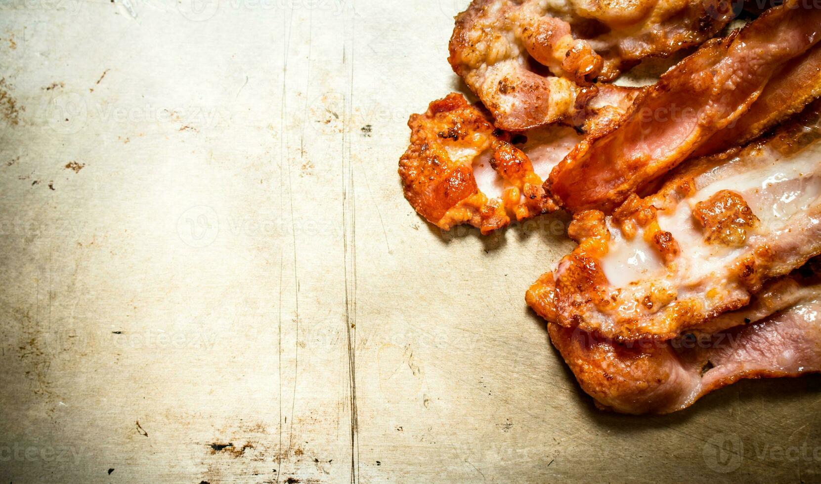 Fried bacon. On old rustic background. photo