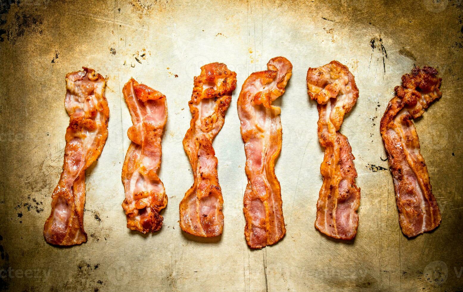 Fried bacon. On old rustic background. photo