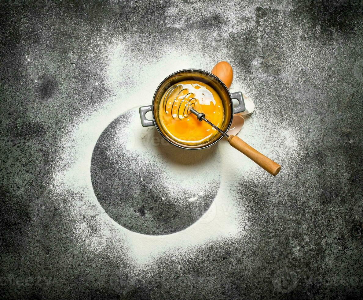 Baking background. Whisking the eggs with the sifted flour. photo