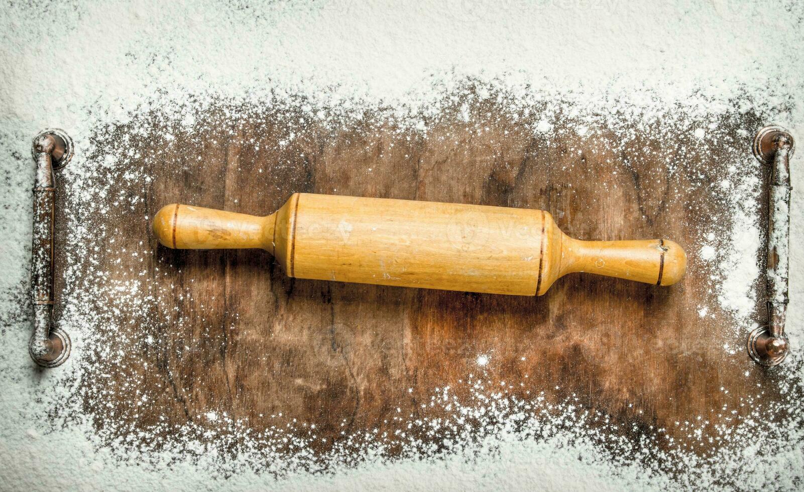 Baking background. Rolling pin for dough on the cutting board. photo