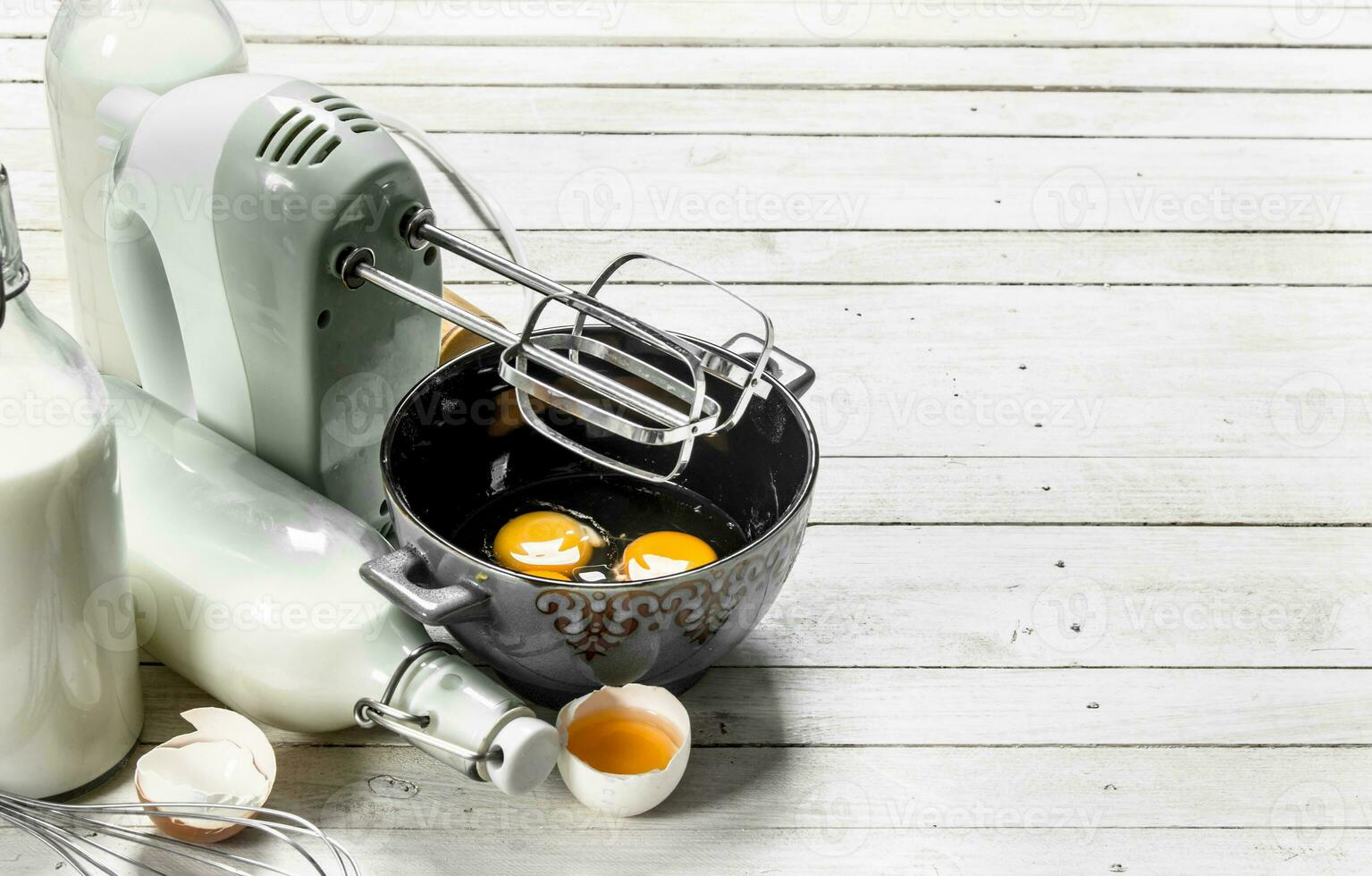 Baking background. Fresh eggs with a mixer. photo