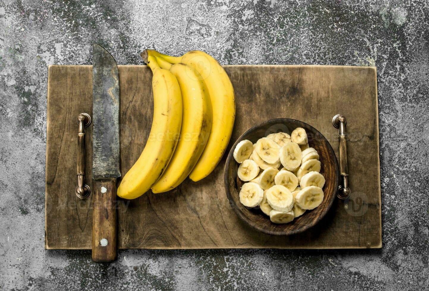 Sliced slices of bananas on an old board. photo