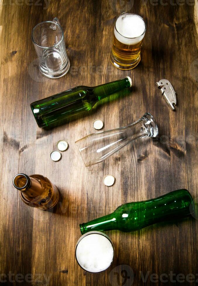 Chaos beer on wooden table. Bottles and glasses of beer . photo