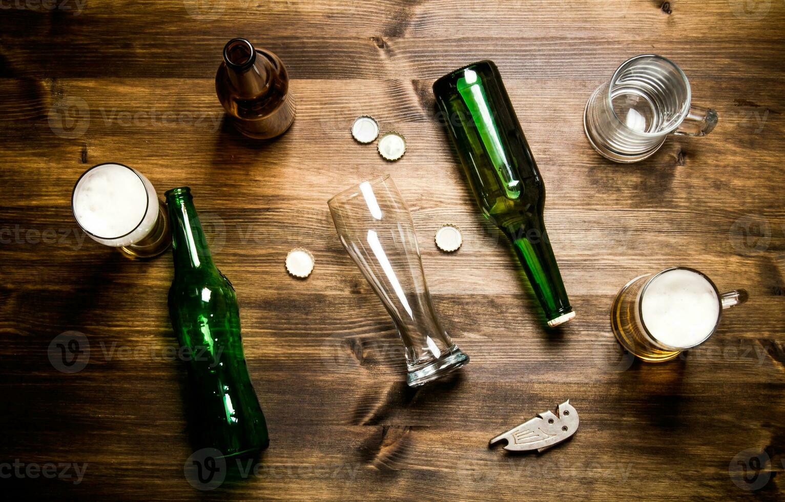 Chaos beer on wooden table. Bottles and glasses of beer . photo