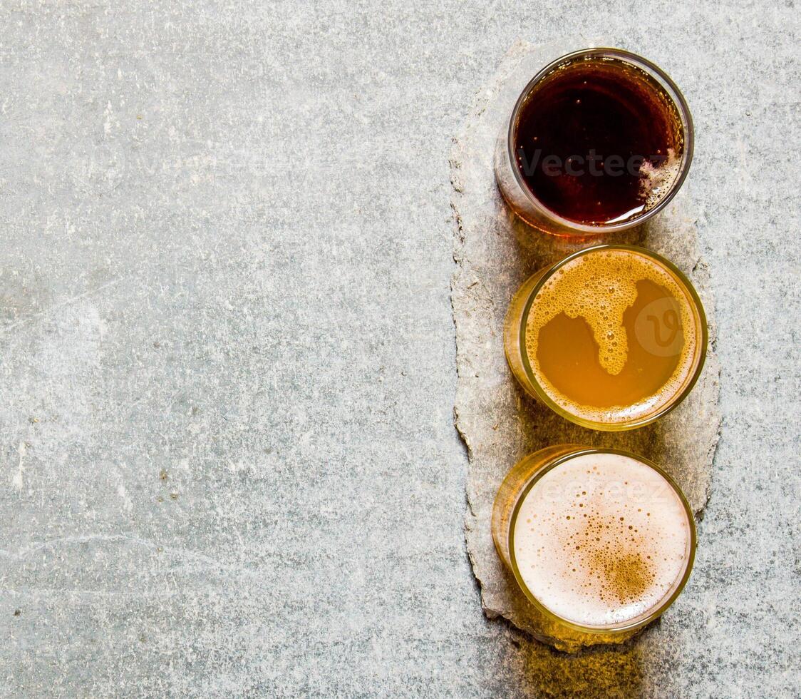 Three beers on stone pedestal. Free space for text. photo