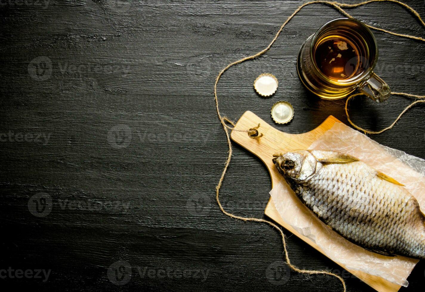 Dried fish and fresh beer on a chalkboard. Free space for text. photo