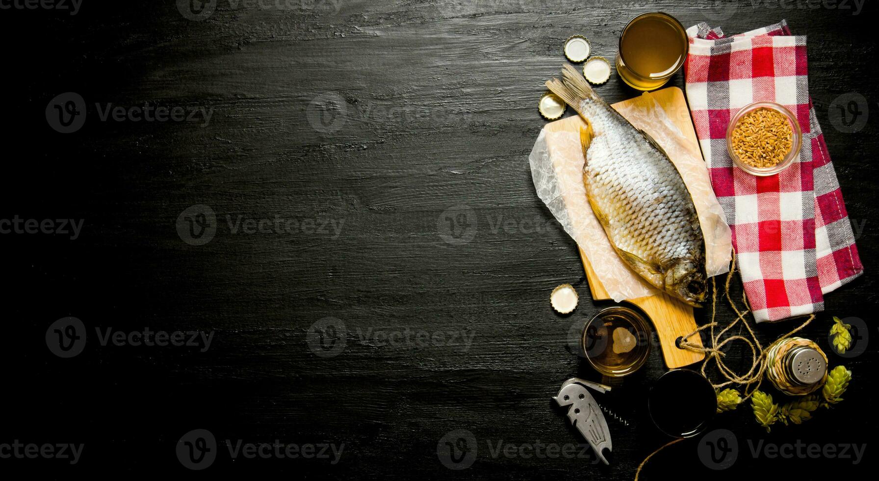 Dried fish and fresh beer on a chalkboard. Free space for text. photo