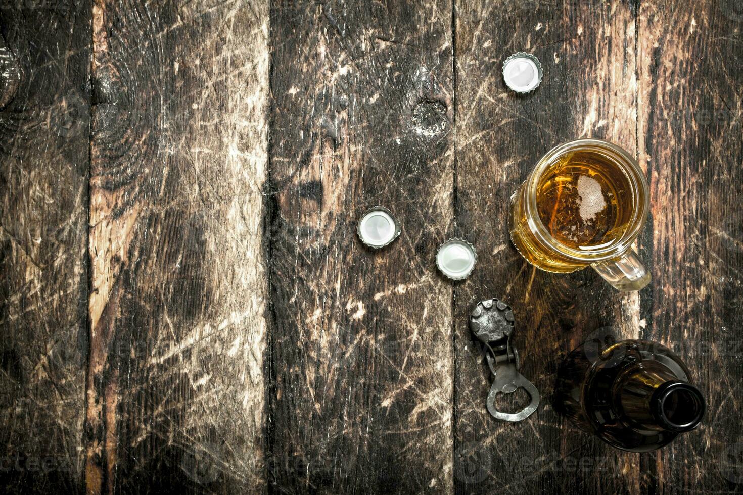 Fresh beer in a glass with stoppers and a bottle opener. photo