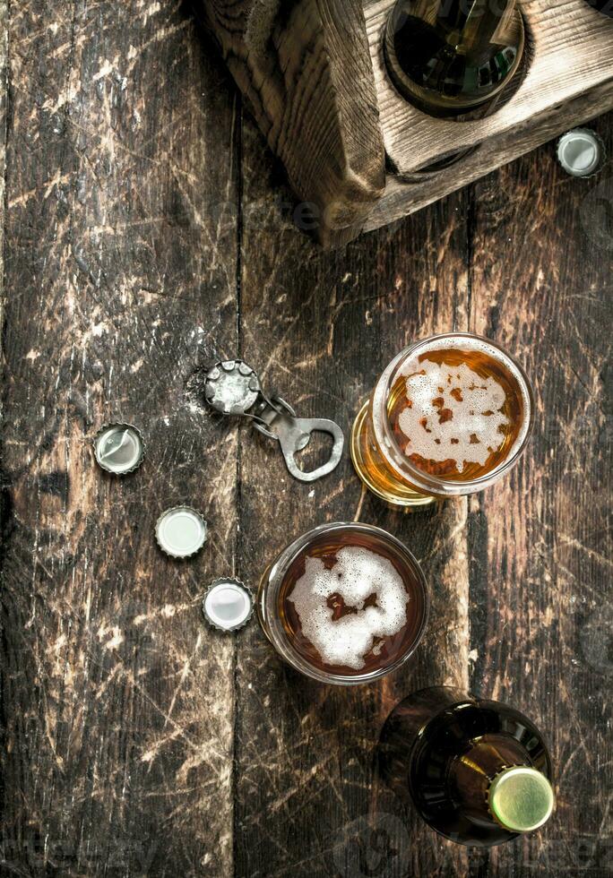 Fresh beer in a glass with stoppers and a bottle opener. photo