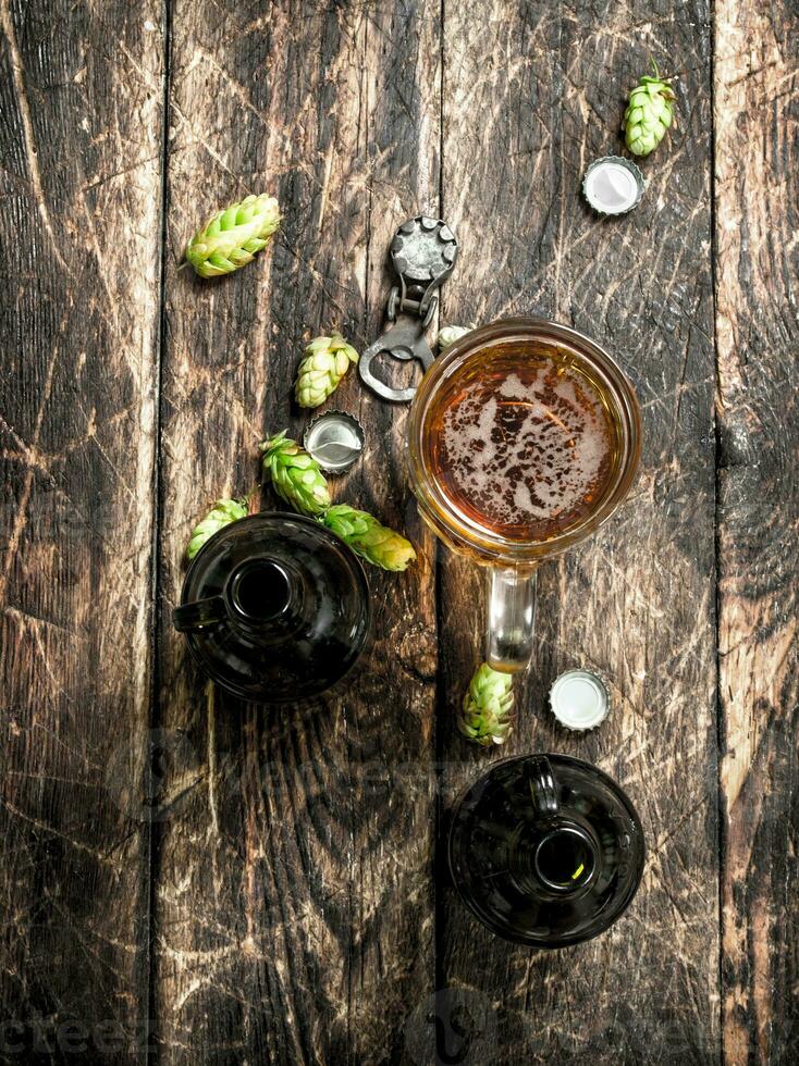 glass of fresh beer with bottles and cork. photo
