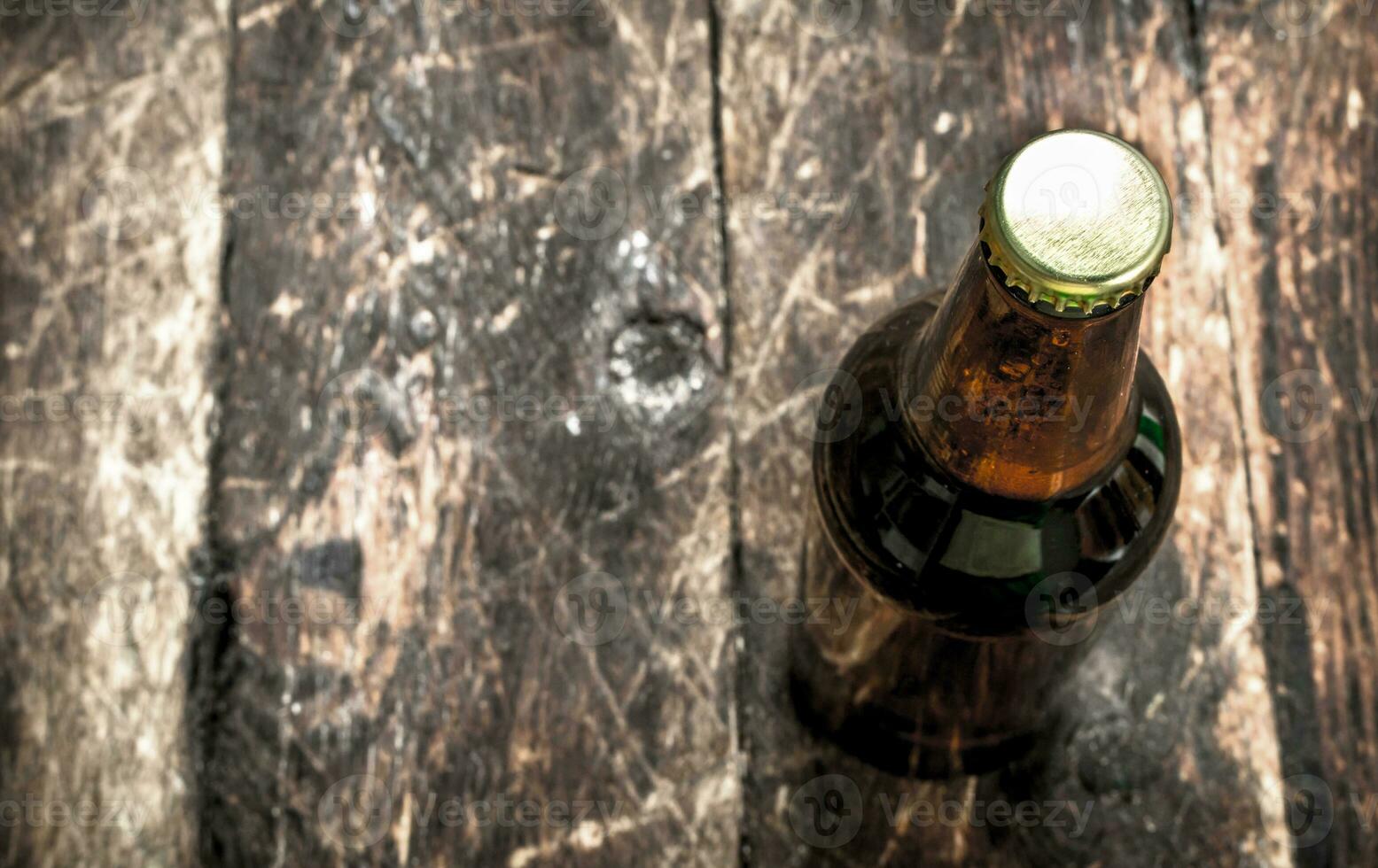 bottle of fresh beer. On wooden background. photo