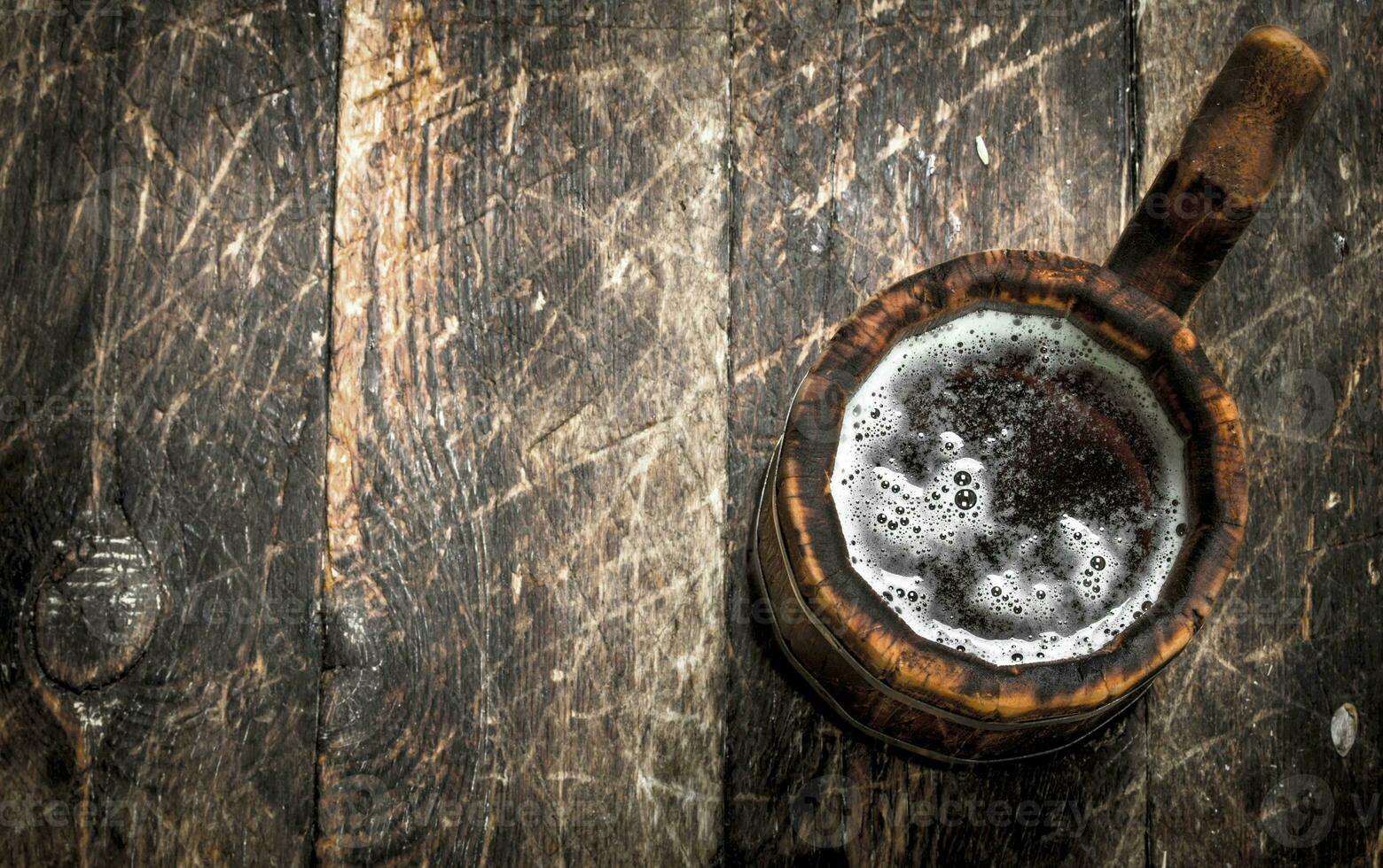 Fresh beer in a wooden mug. photo