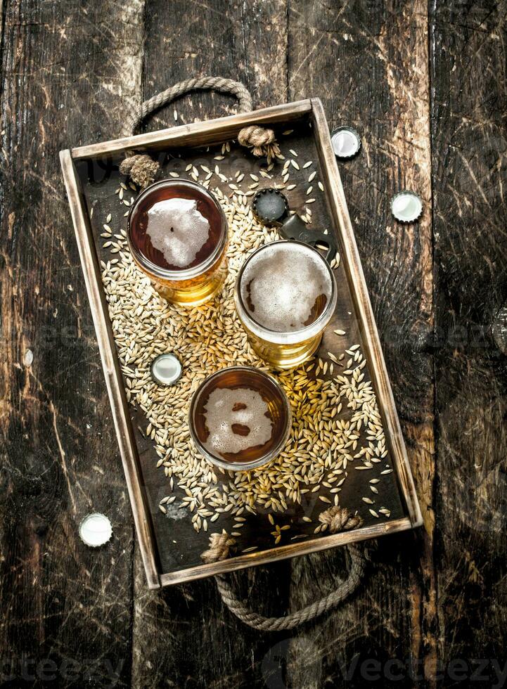 Glasses with fresh beer on an old tray. photo