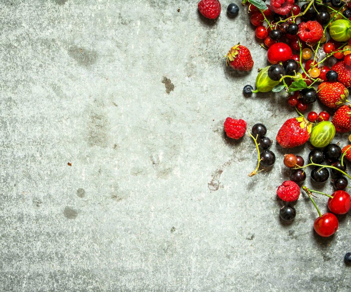 Different berries on the stone table. photo