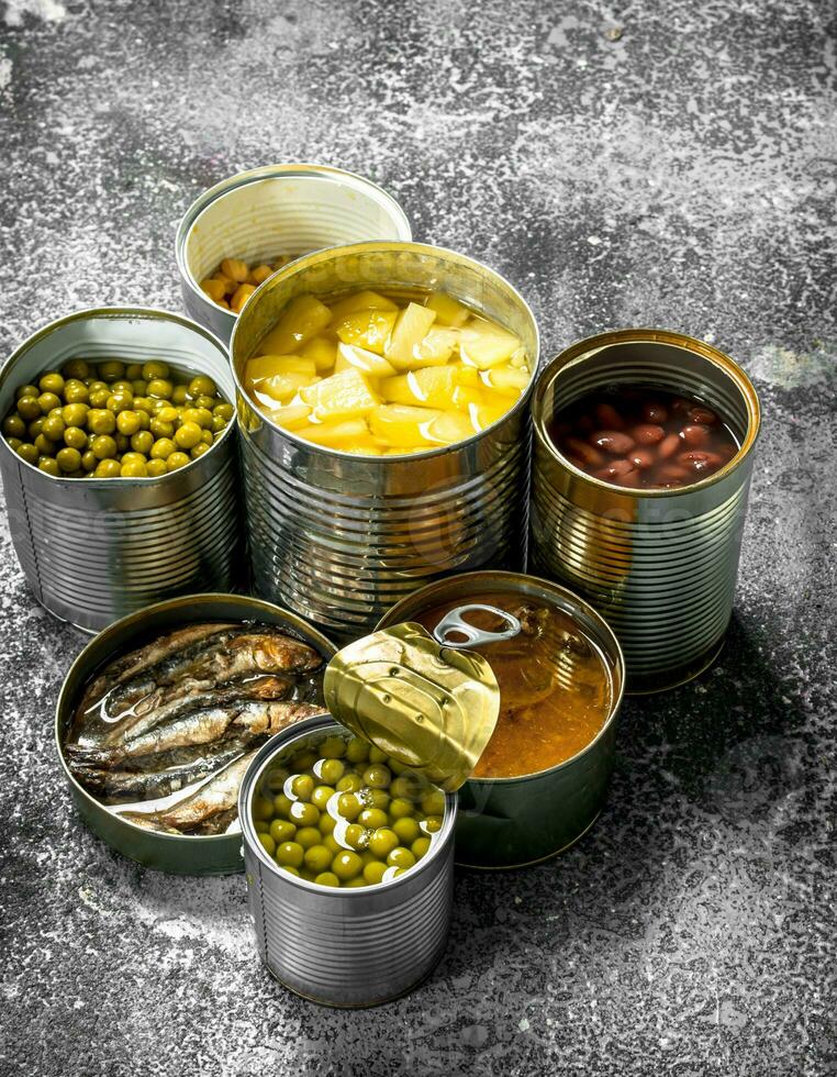 Various canned foods with meat, fish, vegetables and fruits in tin cans. photo