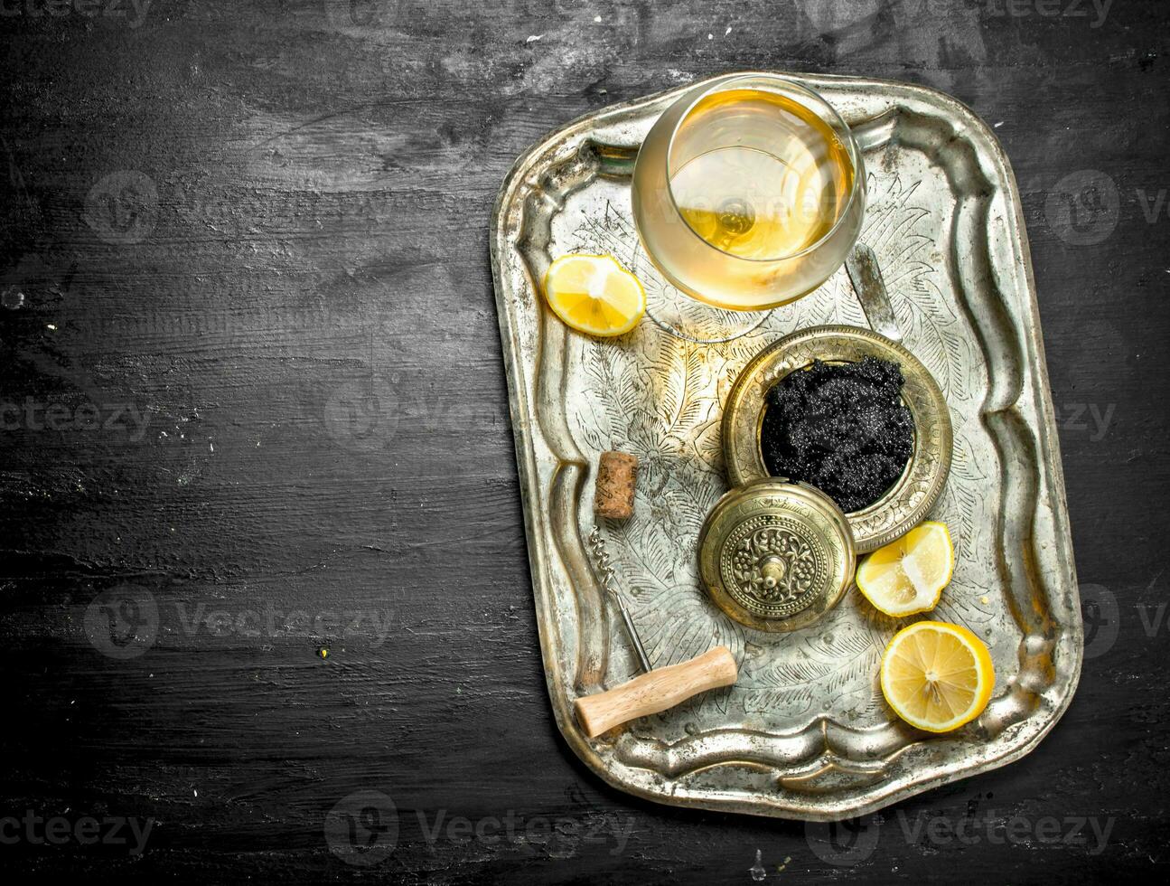 Black caviar with white wine on the old tray. photo