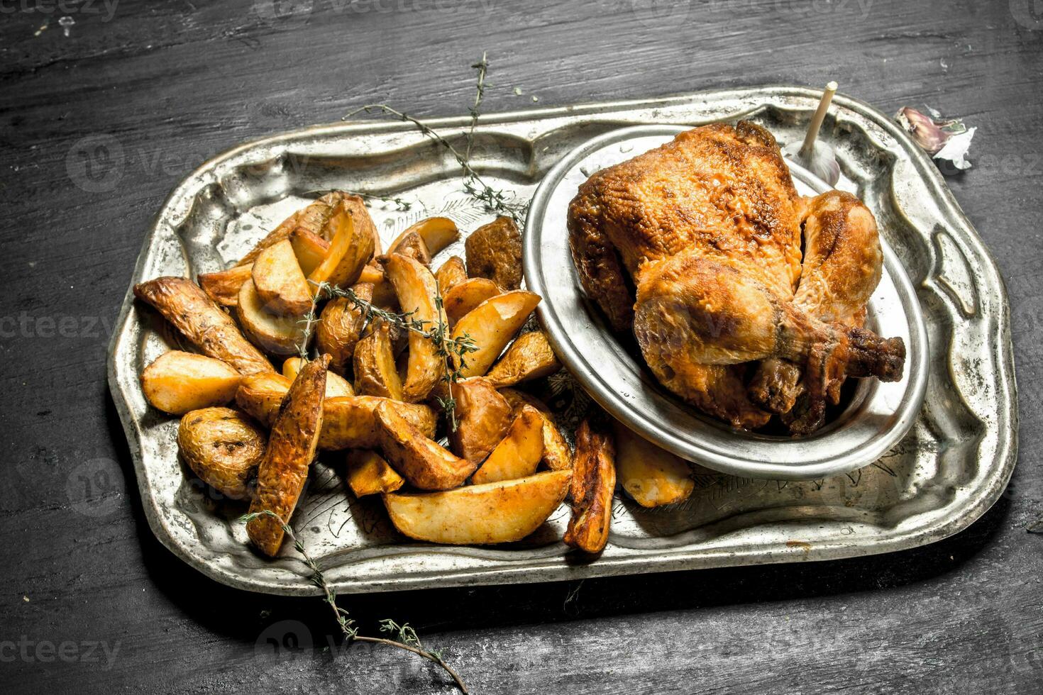 Fried chicken with potatoes on a tray. photo