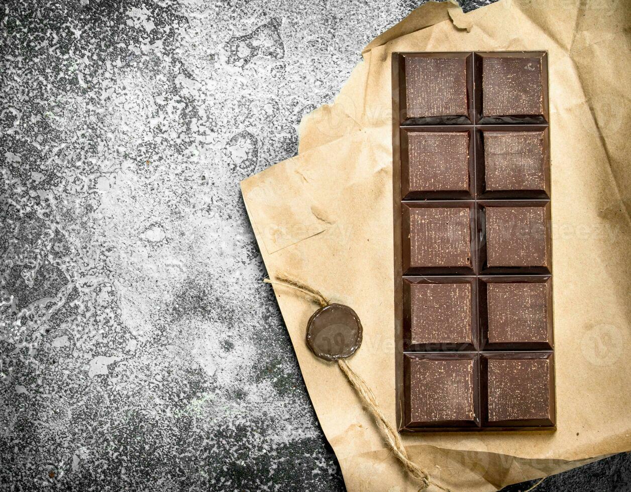 Chocolate bar in a paper wrapper. photo