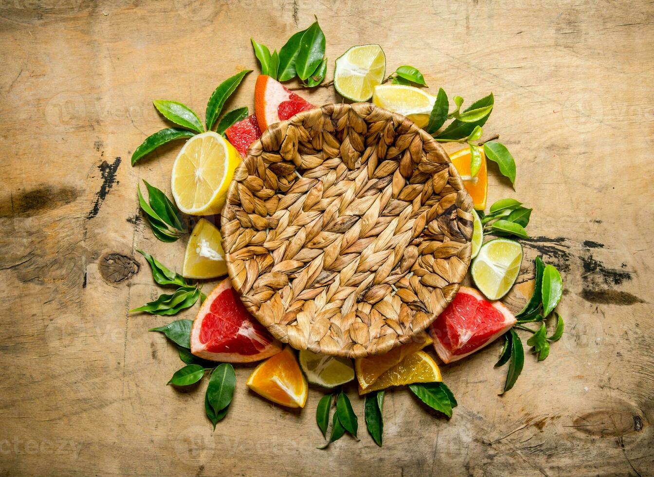 Empty the basket and citrus - grapefruit, orange, tangerine, lemon, lime with leaves. photo