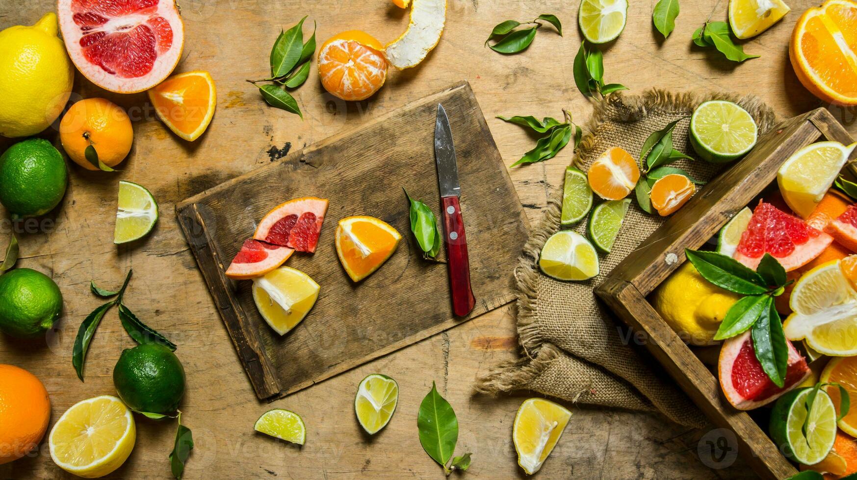 Sliced citrus fruits - grapefruit, orange, tangerine, lemon, lime on the old Board with box. photo