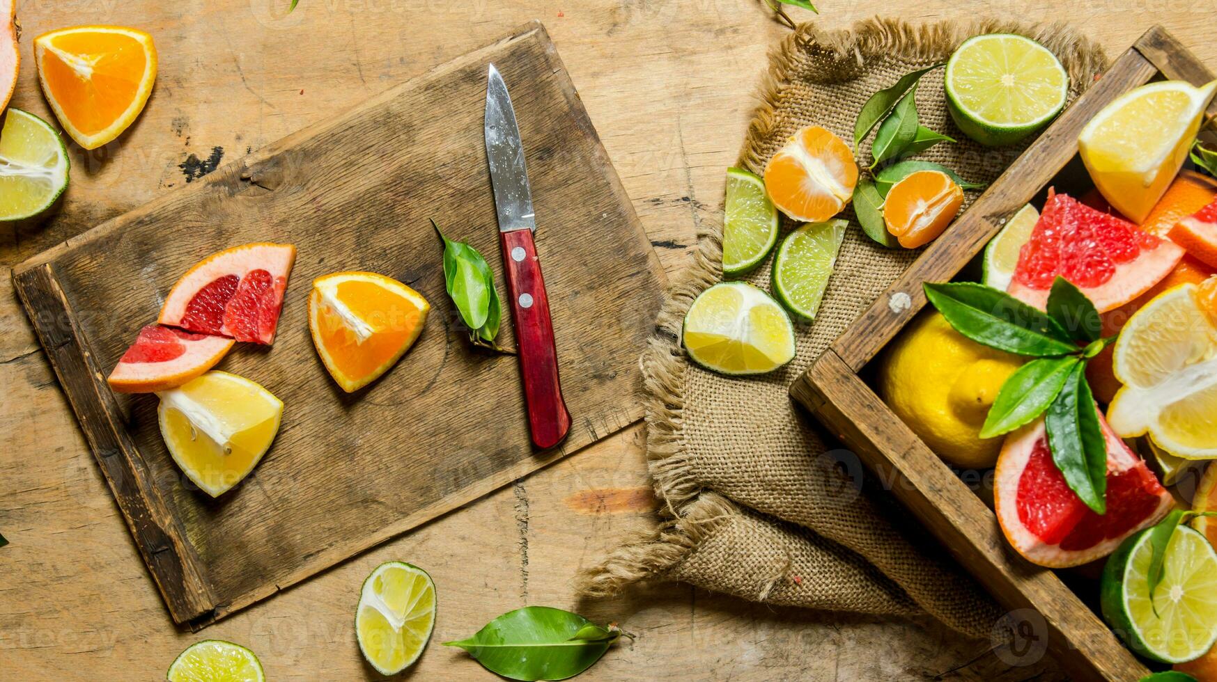 Sliced citrus fruits - grapefruit, orange, tangerine, lemon, lime on the old Board with box. photo