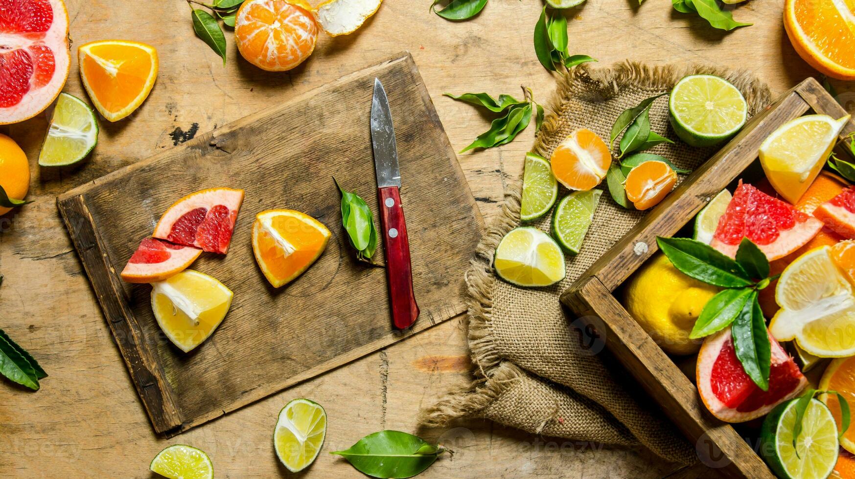 Sliced citrus fruits - grapefruit, orange, tangerine, lemon, lime on the old Board with box. photo