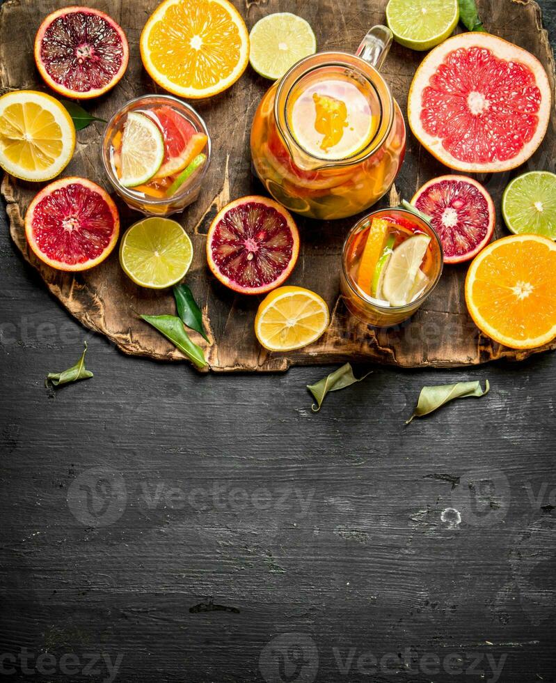 Citrus background. Fresh citrus juice with slices of limes, oranges, grapefruits and lemons. photo