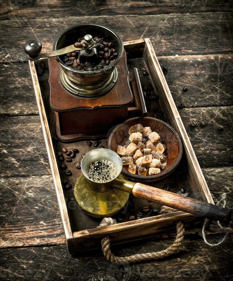 Fresh coffee with sugar and coffee beans on an old tray. photo