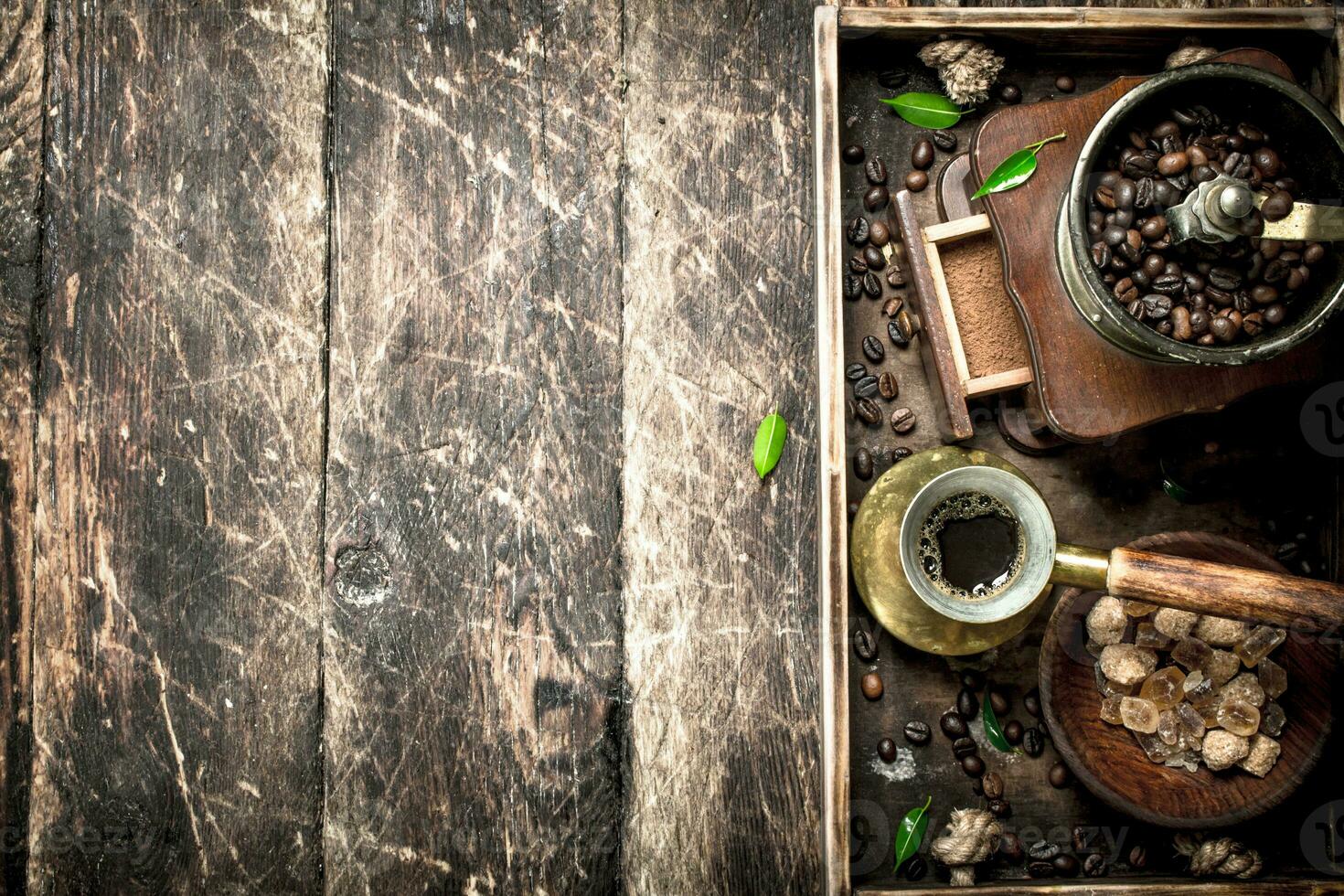 Fresh coffee with sugar and coffee beans on an old tray. photo