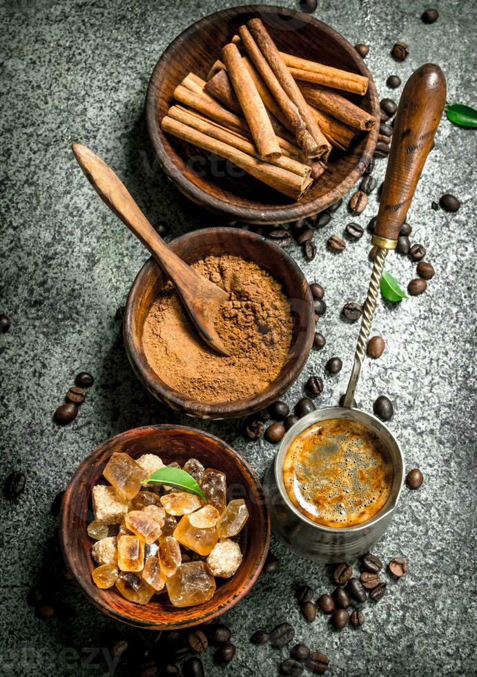 Coffee background. Coffee in turkey with crystals of sugar, cinnamon and ground coffee. photo