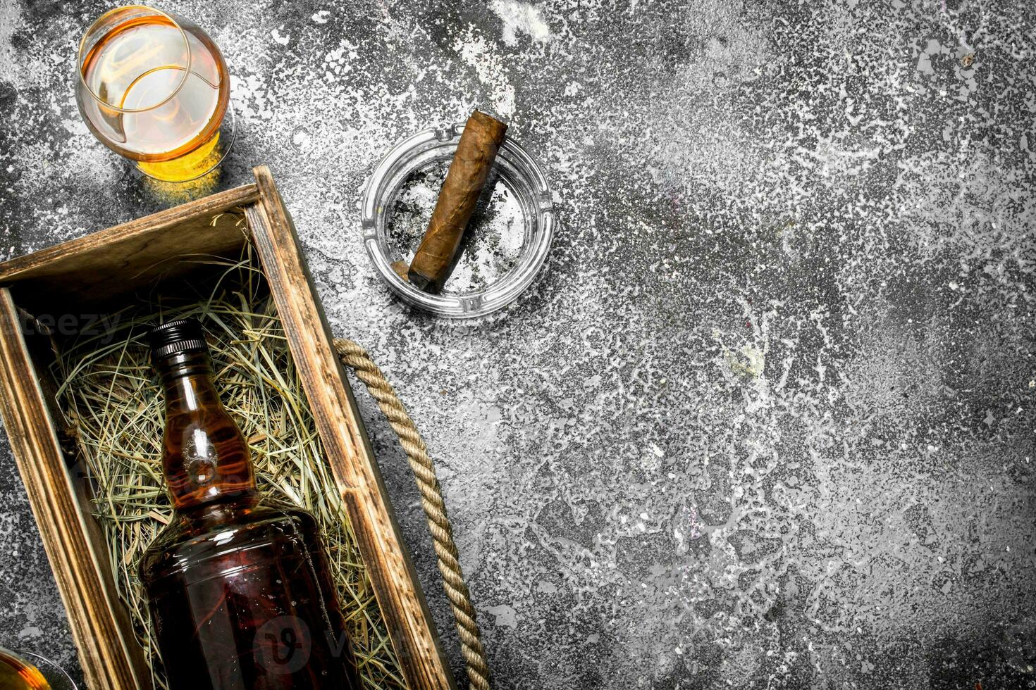 bottle of cognac in an old box with a cigar. photo