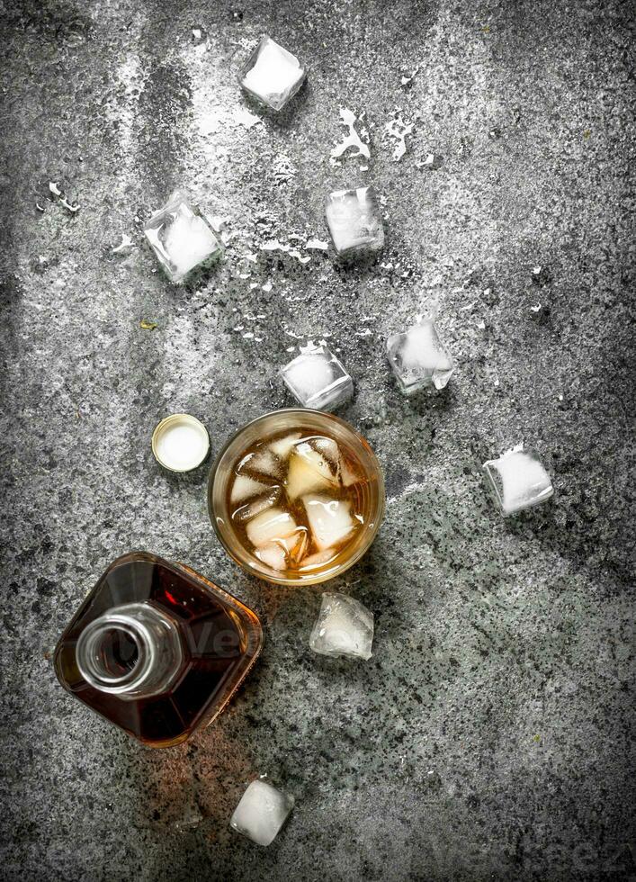 glass of whiskey with ice cubes. photo