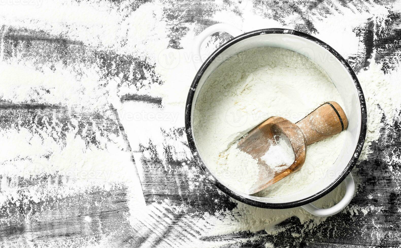 Flour with a shovel in a saucepan. photo