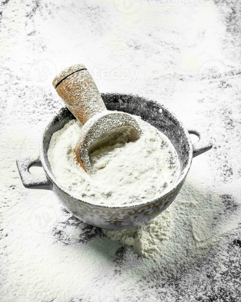 Flour with a scoop in a bowl. photo
