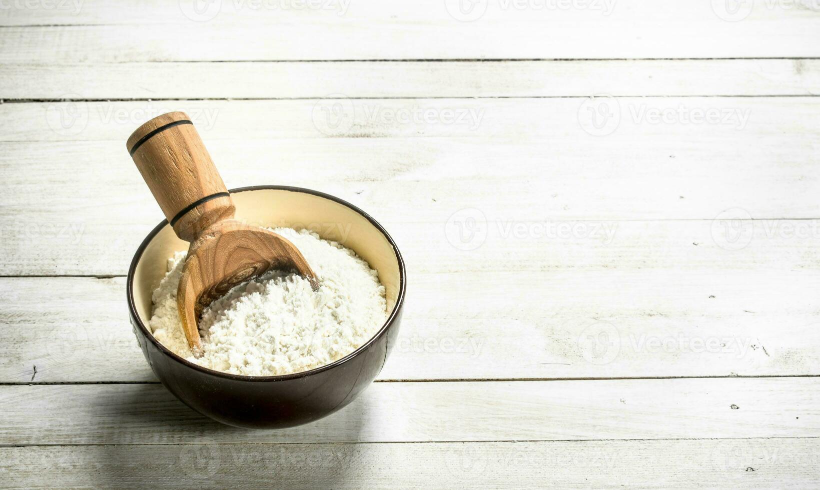 Flour with a scoop in a bowl. photo
