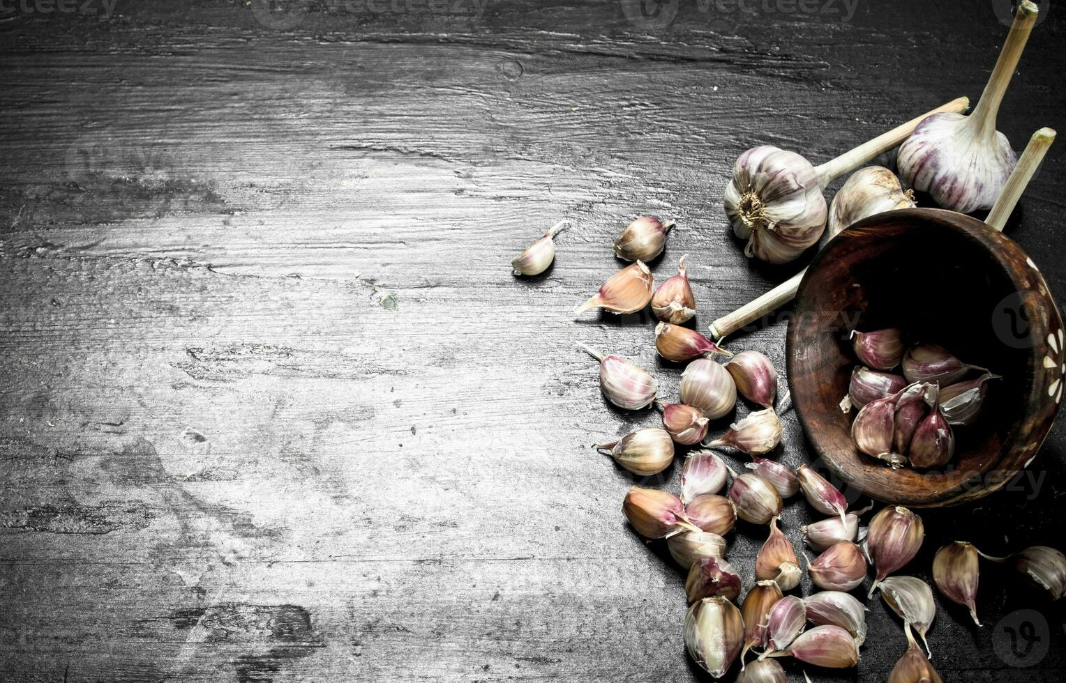 Pieces of fresh garlic in a wooden bowl. photo