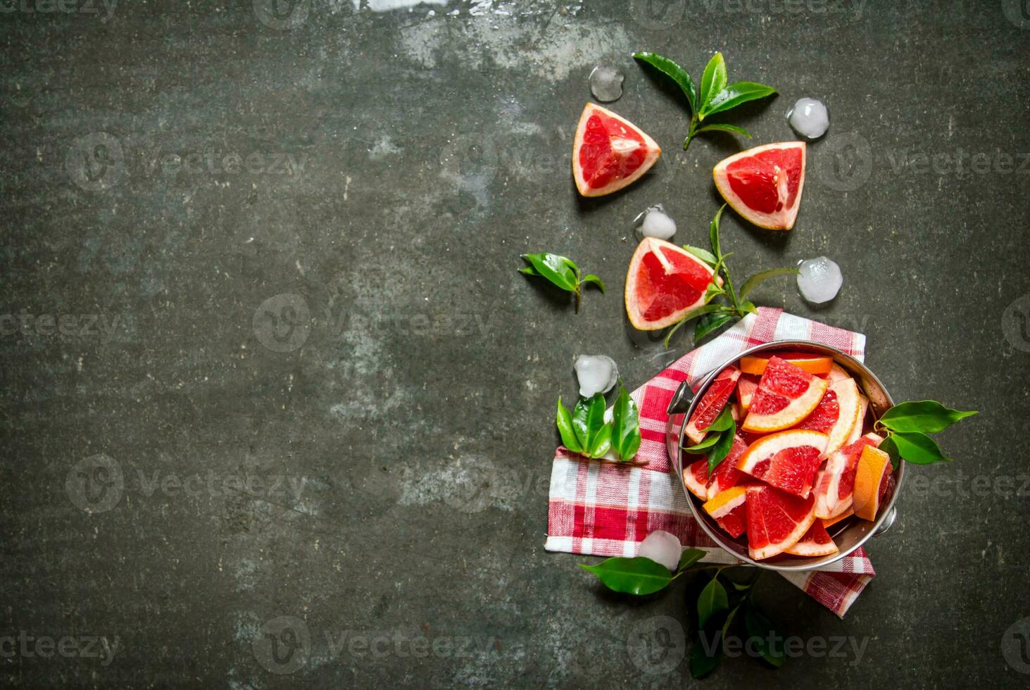 Cut the grapefruit with leaves in the bucket. photo