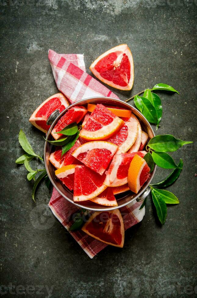 Cut the grapefruit with leaves in the bucket. photo
